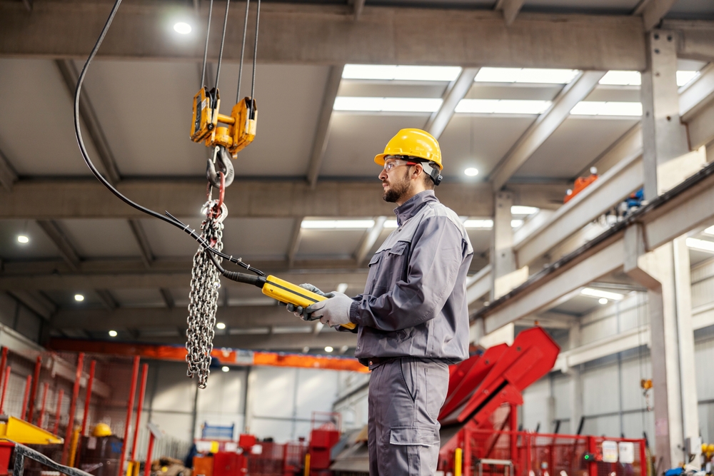Ein Arbeiter bedient einen elektrischen Wandschwenkkran